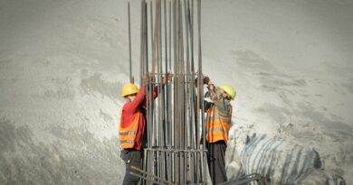 Two construction workers assembling steel reinforcement at a building site